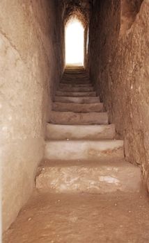 a narrow passage with a stone staircase leading up