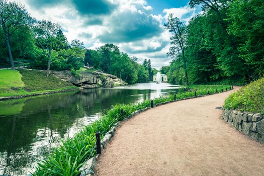 forest landscape, the road near the lake with fountain