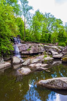 landscape lake with a waterfall and white swan