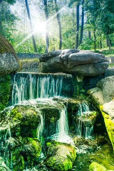 green forest with a waterfall, spring sunny day