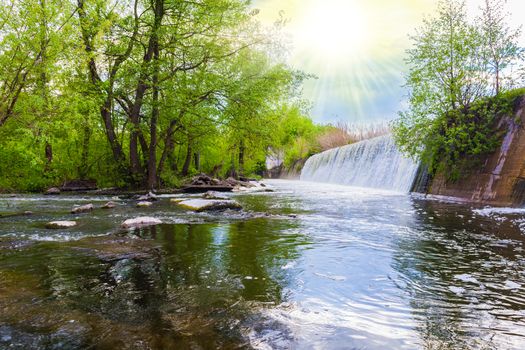 spring landscape waterfall flows into the river