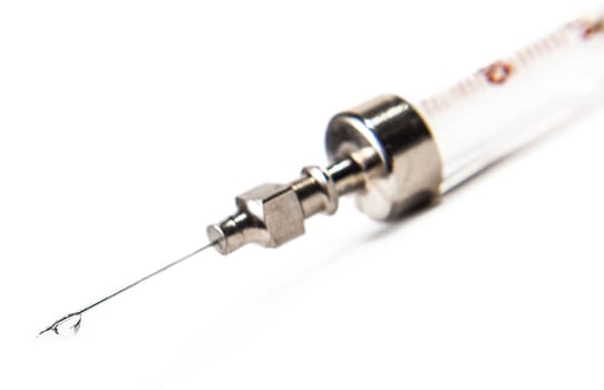 drop on syringe needle on white background