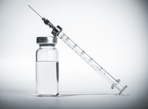 syringe with vial of medication closeup, medicine background