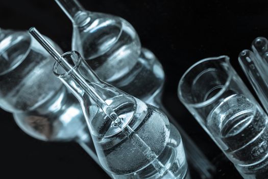 set of chemical glass vials with reflection on a dark background