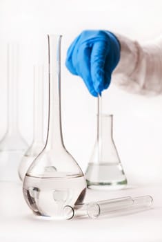 assistant mix reagents into the flask on a white background