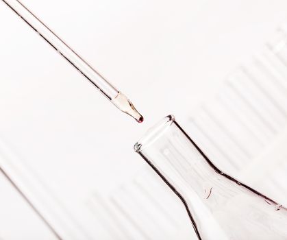 chemical dropper with a drop of closeup on a light background