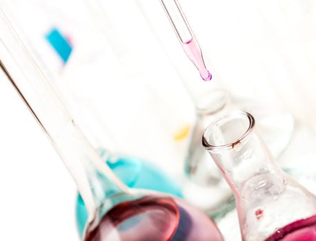 drop falls from the pipette in a flask on a light background