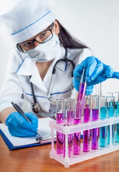 laboratorian examines the contents of the test tubes closeup on a light background