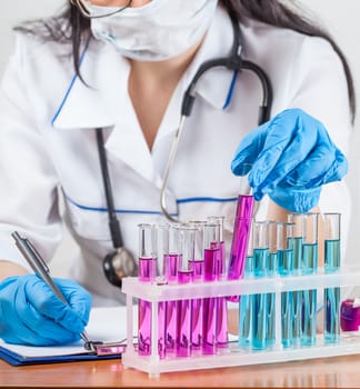 laboratorian examines the contents of the test tubes closeup