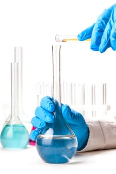 assistant reagent pours into the flask from a test tube on a white background