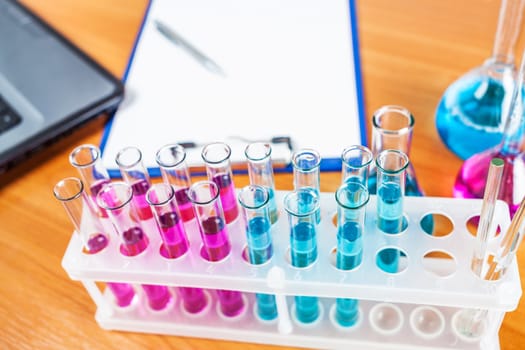 test tubes and flasks with reagents closeup on wooden background