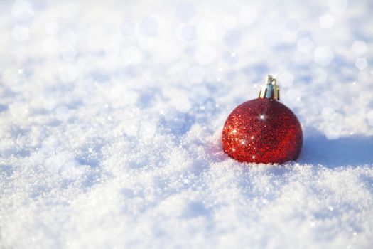 shiny christmas decoration lying on snow background