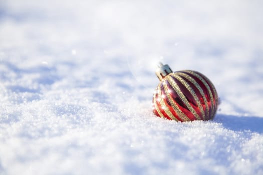 bright christmas decoration ball on a snowy background