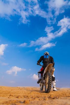 racer on a motorcycle in the desert, in the day