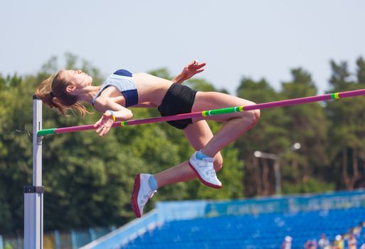 sportswoman jumps in height, sports background