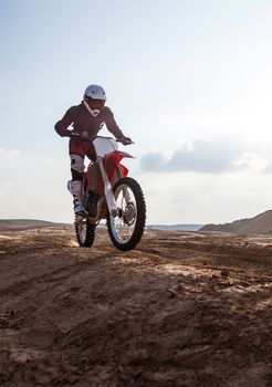 rider performs stunts on a motorcycle in the desert