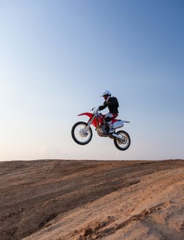 rider performs stunts on a motorcycle in the desert