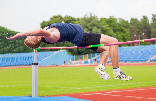 athlete jumps in height, sports background