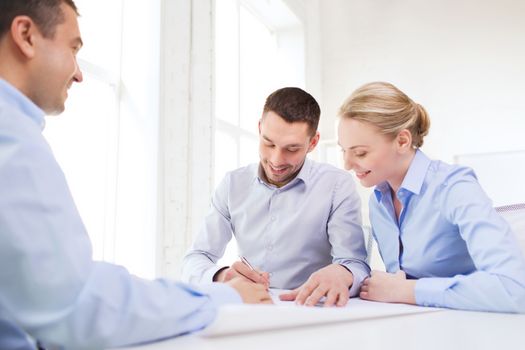 business, people and teamwork concept - smiling business team with papers meeting in office