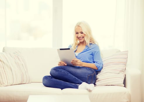 business, technology and e-learning concept - smiling woman with tablet pc computer at home