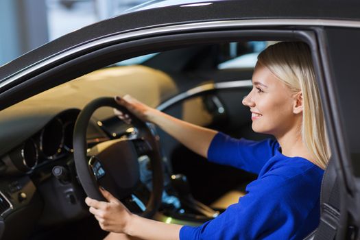 auto business, car sale, consumerism , transportation and people concept - happy woman sitting in or driving car