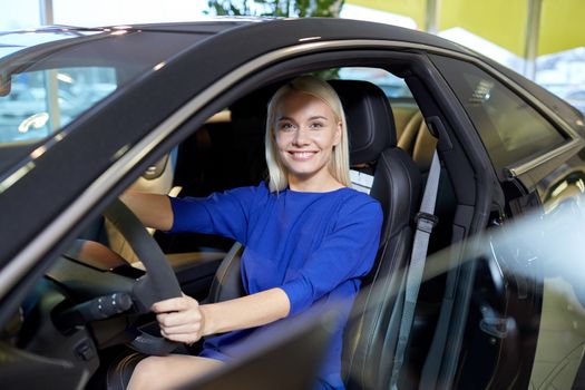 auto business, car sale, consumerism , transportation and people concept - happy woman sitting in or driving car