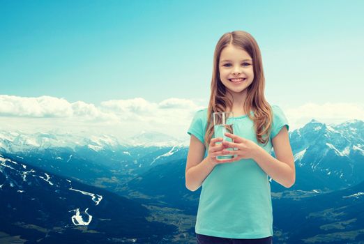 health and beauty concept - smiling little girl with glass of water