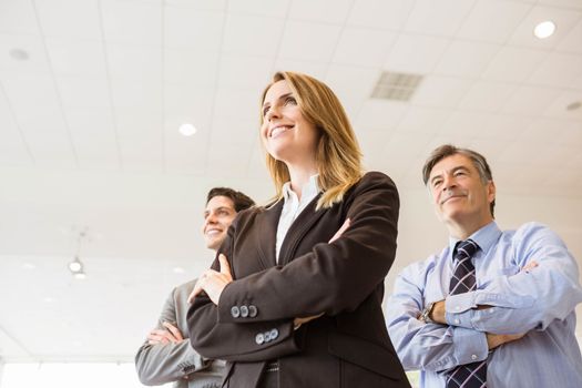 Group of smiling business team standing together at new car showroom