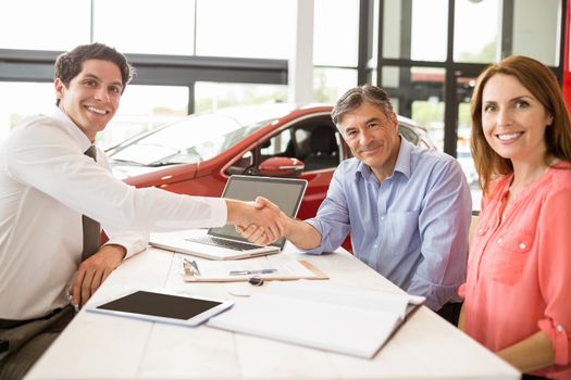 Customers signing some important documents at new car showroom