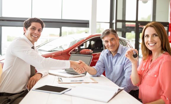 Customers signing some important documents at new car showroom