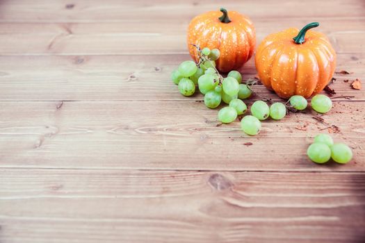 Pumpkin ornaments on desk with grapes