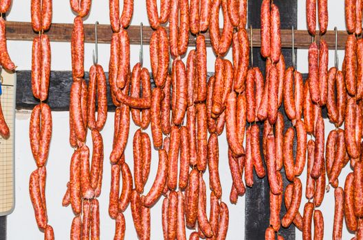 Smoked homemade sausage hanging in a butcher's shop for sale.