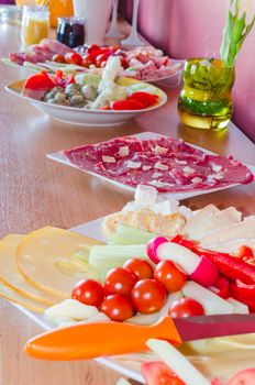 Buffet for a private party with salads and finger food on a cabinet.