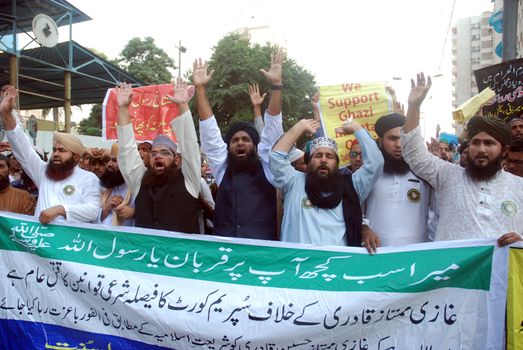 PAKISTAN, Karachi: Islamist supporters of Mumtaz Qadri march through Karachi, Pakistan on October 28, 2015 to speak out against his death sentence. Qadri, a police bodyguard, was convicted of murder after he reportedly shot and killed Punjab Governor Salman Taseer in Islamabad in 2011, due to the governor's support of liberal reforms to Pakistan's blasphemy law.