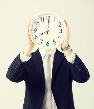 man covering his face with wall clock