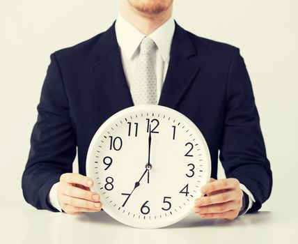 close up of man holding wall clock