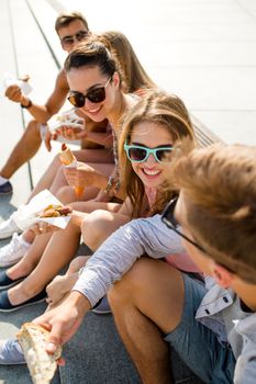 friendship, leisure, summer and people concept - group of smiling friends in sunglasses sitting with food on city square