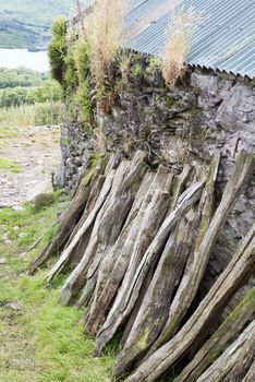 wood stacked against the wall of a farm shed in ireland