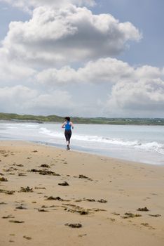 young woman jogging on the beach in ballybunion county kerry ireland