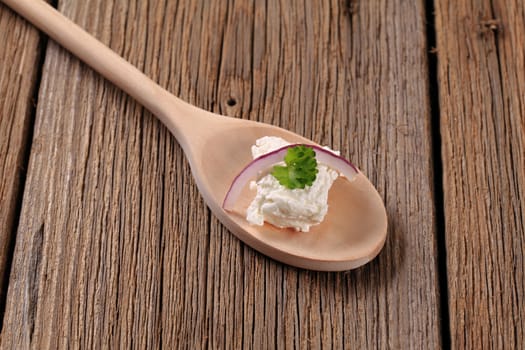 Fresh cheese on a wooden spoon 