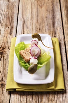 Mozzarella cheese, capers and onion on a wooden skewer