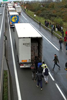 FRANCE, Calais: Migrants from the New Jungle migrant camp in Calais walk along the A16 highway, on October 28, 2015. Around 6.000 migrants live in the new Jungle with the hope of crossing the Channel to Britain.