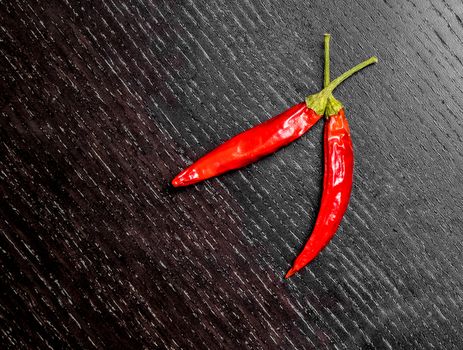 spicy hot tomato peppers as snack or appetizer on black wood table