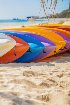 Row of colorful kayaks at sea shore on Tangalooma Island, Queensland.