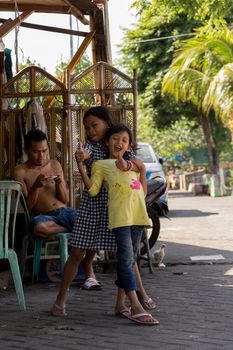 MANADO, NORTH SULAWESI, INDONESIA - AUGUST 5, 2015: Indonesian girls with family in Manado shantytown on August 5, 2015 in Manado, North Sulawesi, Indonesia