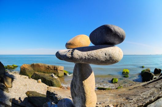 Balanced stack of pebbles on the stony seashore