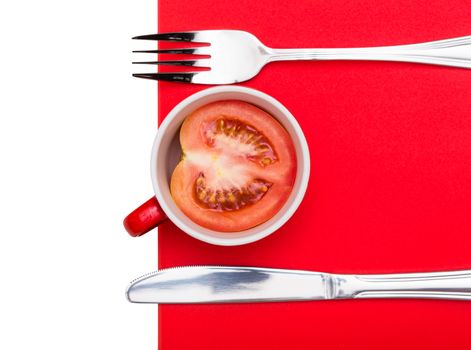 tomato in a bowl with a fork and knife