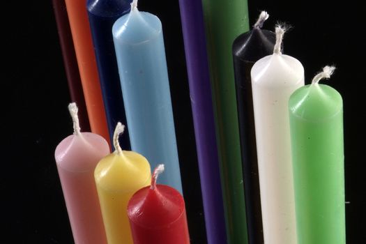 group of colorful cylindrical candles on a black background