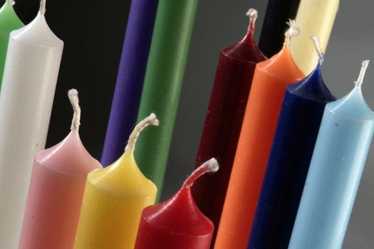 group of colorful cylindrical candles on a black background