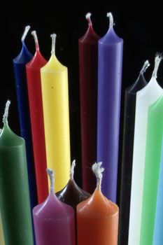 group of colorful cylindrical candles on a black background